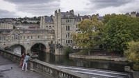 Wisatawan berfoto dengan latar belakang pemandangan kota Bath di Inggris, Senin (3/10/2022). Berkunjung ke Kota Bath tak hanya memberikan pengalaman melihat tempat bersejarah dengan barang-barang peninggalannya yang autentik dan magis, tetapi juga merasakan nuansa kehidupan bangsa Romawi pada era itu.  