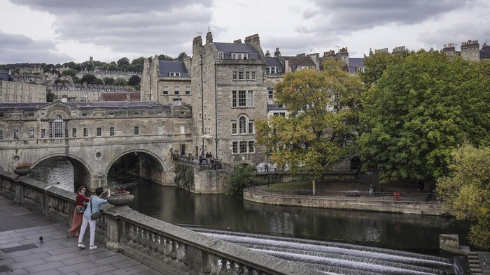 Wisatawan berfoto dengan latar belakang pemandangan kota Bath di Inggris, Senin (3/10/2022). Kota Bath didirikan oleh bangsa Romawi di abad pertama saat mereka menemukan sumber air panas alami yang bisa dijadikan spa dan merupakan salah satu situs warisan dunia UNESCO yang terdapat di Inggris. ANTARA FOTO/Dhemas Reviyanto/aww.