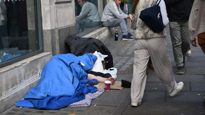 A homeless man sleeps in his sleeping bag on The Strand in central London on October 1, 2022, as campaigners gather in the city to protest against the cost of living crisis. (Photo by JUSTIN TALLIS / AFP) (Photo by JUSTIN TALLIS/AFP via Getty Images)