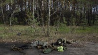Mayat prajurit Rusia tergeletak di tanah di kota Lyman, Ukraina, Senin (3/10/2022). Kondisi kota Lyman pun hancur akibat perang.   