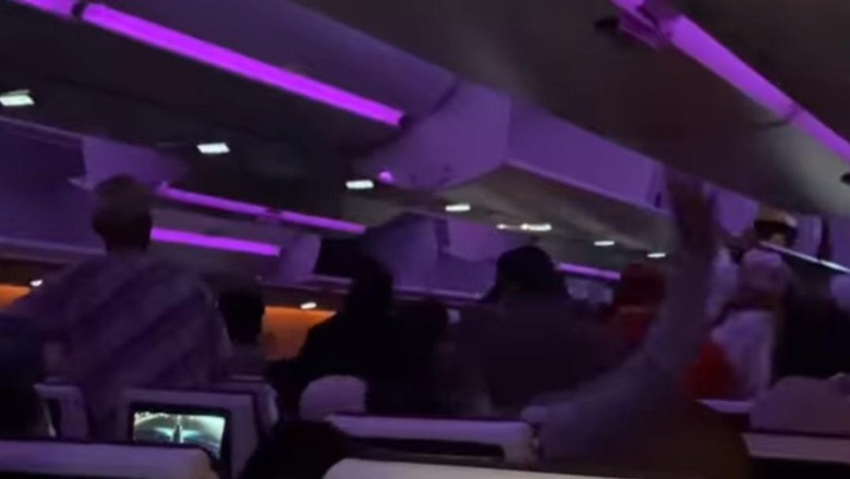 Penumpang buru-buru berdiri di pesawat Qatar Airways Penumpang buru-buru berdiri di pesawat Qatar Airways