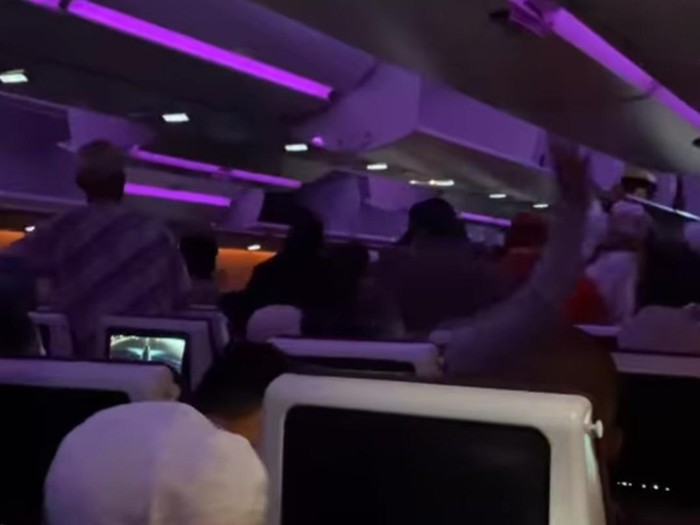 Penumpang buru-buru berdiri di pesawat Qatar Airways