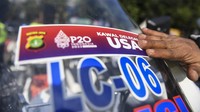Personel kepolisian menempelkan stiker pengawalan delegasi di kendaraan sepeda motor pada saat apel.