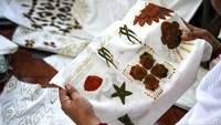 Pola batik digambar dan ditulis di atas kain putih.