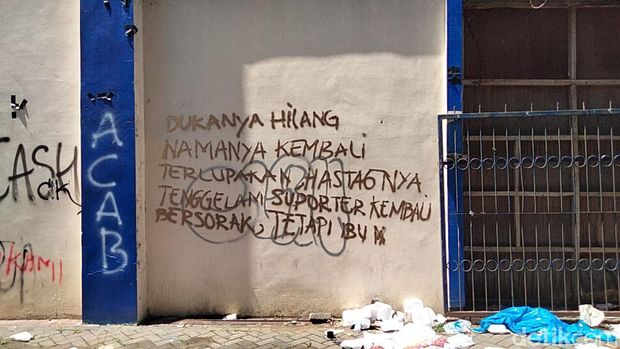Protes dan cacian di tembok Stadion Kanjuruhan, Malang