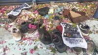 Sepatu milik korban Tragedi Kanjuruhan yang berserakan di stadion dipenuhi taburan bunga (Foto: Deny Prastyo Utomo/detikJatim)