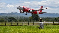 Seorang petani melihat pesawat AirAsia yang berangkat ke Malaysia untuk pertama kalinya. Pembukaan kembali rute internasional ini menghubungkan Kuala Lumpur dengan tiga kota utama di Sumatera yakni Banda Aceh, Padang, dan Pekanbaru.