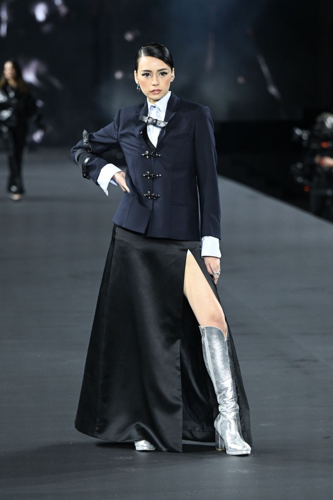 Tamara Dai tampil memesona dengan perpaduan gaya nautical dan preppy. Konten kreator asal Indonesia ini memadukan jaket Paddington, kemeja dan rok hitam berbelahan paha tinggi. Foto: Getty Images