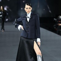 Tamara Dai tampil memesona dengan perpaduan gaya nautical dan preppy. Konten kreator asal Indonesia ini memadukan jaket Paddington, kemeja dan rok hitam berbelahan paha tinggi. Foto: Getty Images