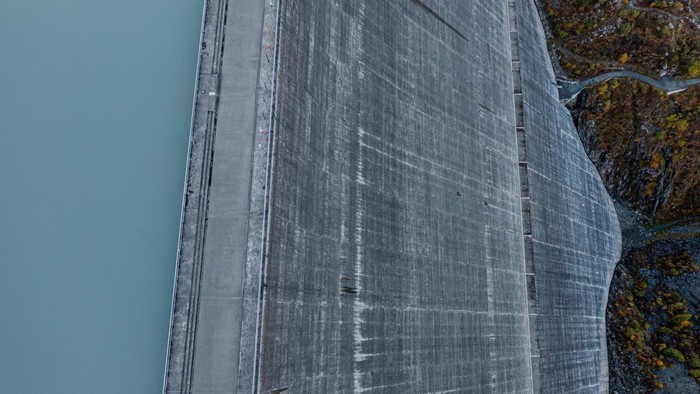 Wow! Bendungan Paling Jangkung di Eropa Diapit Perbukitan HEREMENCE, SWITZERLAND - OCTOBER 03: In this aerial view the Grande Dixence dam stands on October 3, 2022 near Heremence, Switzerland. The dam, which at 285 meters is the tallest in Europe, supplies water to four hydroelectric power stations, including the 1,269 megawatt Bieudron Power Station. Switzerland, in a bid to prepare for possible energy shortfalls this winter, has temporarily reduced the amount of water some dam operators are required to send into nearby streams, increasing the water available to hydroelectric stations. Switzerland generates approximately 60% of its electricity with hydropower. (Photo by Robert Hradil/Getty Images)