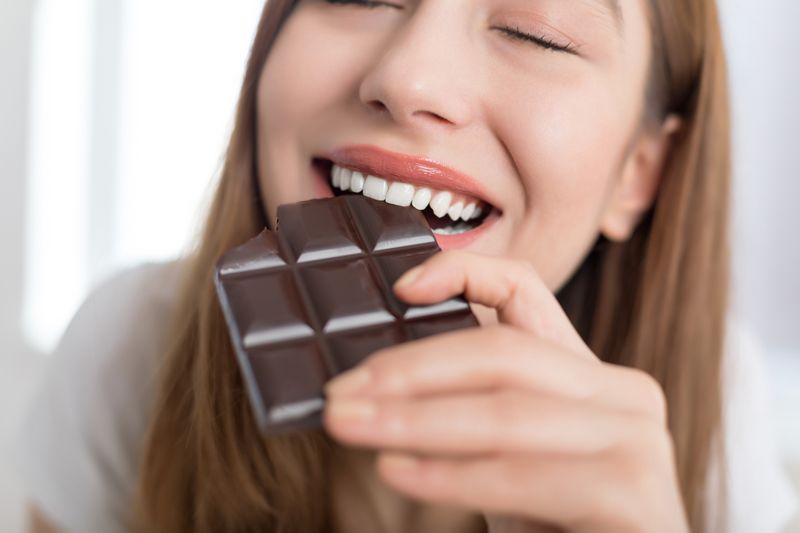 Woman biting a chocolate bar