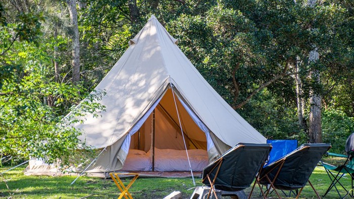 Glamping camping teepee tent and chairs at the campsite.