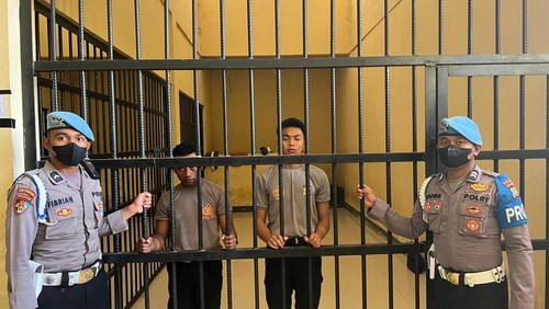 2 Oknum Polisi Papua Barat saat di sel karena menjilat kue ulang tahun ke-77 TNI.