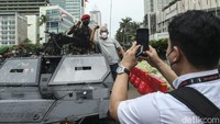 Warga berfoto dengan prajurit TNI di atas alutsista di Kawasan Bundaran HI, Jakarta, Rabu (5/10/2022). Warga yang datang lantas mengabadikan momen tersebut dengan menggunakan smartphone.