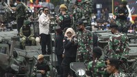 Seorang warga berfoto dengan prajurit TNI di atas alutsista di Kawasan Bundaran HI, Jakarta, Rabu (5/10/2022). Deretan alutsista dipajang usai para prajurit TNI menggelar parade.