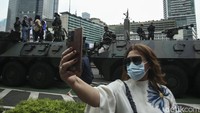 Seorang warga selfie di depan parade alutsista di Kawasan Bundaran HI, Jakarta, Rabu (5/10/2022). Parade ini digelar sebagai rangkaian peringatan Hari Ulang Tahun (HUT) ke-77 TNI.