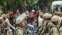 Warga menonton parade alutsista pada perayaan HUT ke-77 TNI di Kawasan Bundaran HI, Jakarta, Rabu (5/10/2022).