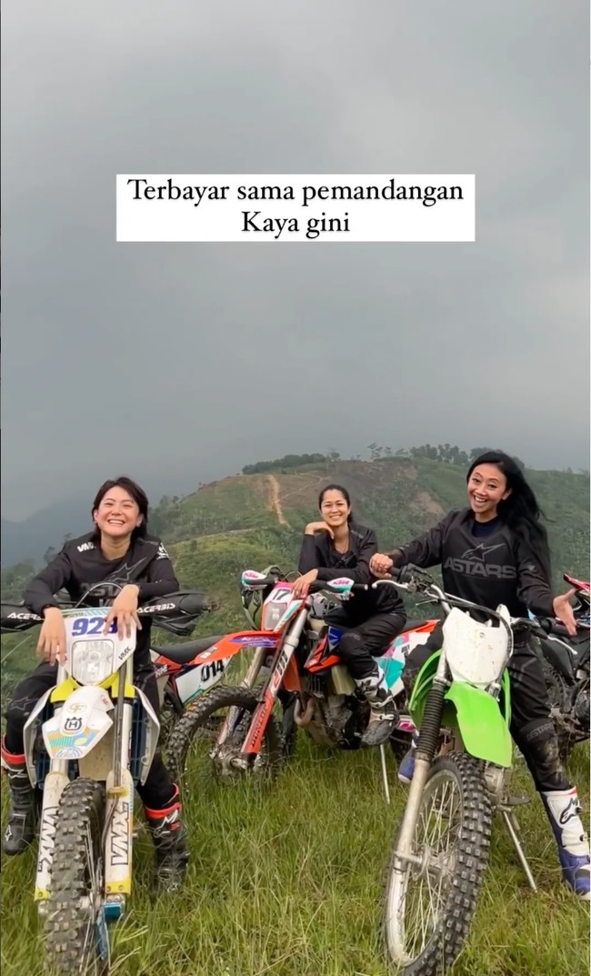 Melihat pemandangan alam yang begitu indah dari atas bukit, perjalanan Asri, Prisia, dan Poppy melewati medan ekstrem pun seolah terbayarkan. Begini penampilan ketiiganya sambil bersantai di atas motor. Foto: Instagram/@popsovia