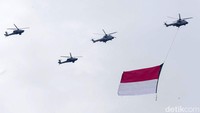 Tampak helikopter membentangkan bendera merah putih.