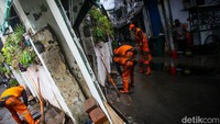 Petugas PPSU Kuningan Barat atau pasukan oranye dikerahkan membersihkan sisa lumpur. 