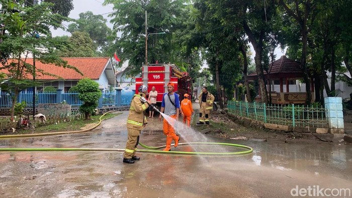 Banjir sempat melanda kawasan Jl Pondok Karya, Mampang Prapatan, Jaksel. Petugas damkar menyemprot sisa lumpur yang terbawa arus banjir. (Mulia Budi/detikcom)