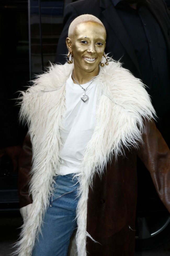 Doja Cat dikenal dengan gaya nyentriknya. Setelah membotaki rambut, kini ia menarik perhatian di Paris Fashion Week dengan wajah berlumuran cat emas. Foto: Getty Images/Julien M. Hekimian