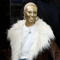 Doja Cat dikenal dengan gaya nyentriknya. Setelah membotaki rambut, kini ia menarik perhatian di Paris Fashion Week dengan wajah berlumuran cat emas. Foto: Getty Images/Julien M. Hekimian