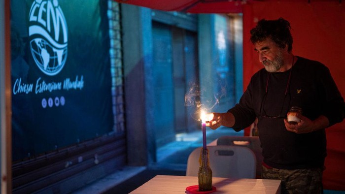 Italia Dilanda Krisis Energi, Restoran Ganti Lampu dengan Lilin Seorang waiters menyalakan lilin di sebuah restoran