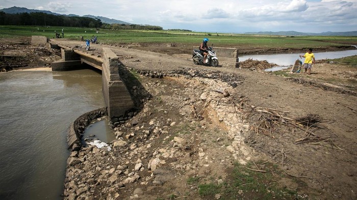 Jalan Lama yang 'Tersembunyi' di Waduk Gajah Mungkur Kini Muncul Pengendara sepeda morot melintasi jembatan jalan lama yang menghubungkan Kecamatan Wuryantoro dengan Eromoko di area Waduk Gajah Mungkur, Wonogiri, Jawa Tengah, Selasa (4/10/2022). Fenomena jalan lama yang hanya muncul saat debit air Waduk Gajah Mungkur menyusut akibat musim kemarau tersebut dimanfaatkan warga melintas untuk mempersingkat jarak dan waktu tempuh perjalanan. ANTARA FOTO/Mohammad Ayudha/tom.