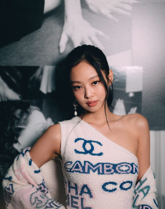 Jennie BLACKPINK tampil memesona memakai one-shoulder dress putih dari koleksi Chanel Spring Summer 2023. Gaun tersebut dipadukan dengan oversized cardigan yang menyelimuti lengannya. Foto: dok. Twitter @jenniesrenes