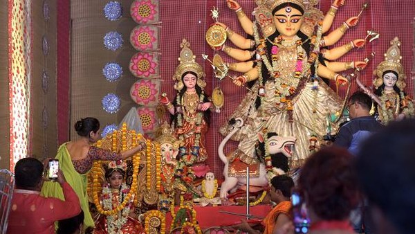 Seorang anak gadis berpakaian seperti dewi duduk di samping patung Dewi Durga selama Festival Durga Puja di Kopar Khairane Bengali, Navi, Mumbai, India, Selasa (4/10/2022). Sang dewi yang dikenal orang Hindu sebagai penumpas kejahatan, dicirikan oleh sepuluh lengannya yang membawa berbagai senjata mematikan, begitu pula kendaraannya, singa. Â Seorang anak gadis berpakaian seperti dewi duduk di samping patung Dewi Durga selama Festival Durga Puja di Kopar Khairane Bengali, Navi, Mumbai, India, Selasa (4/10/2022). Sang dewi yang dikenal orang Hindu sebagai penumpas kejahatan, dicirikan oleh sepuluh lengannya yang membawa berbagai senjata mematikan, begitu pula kendaraannya, singa. Â
