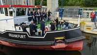 Beberapa tamu kehormatan dan Volker Wissing (ke-5 dari kiri, FDP), Menteri Federal Transportasi dan Digital, memotong pita di kapal pemecah es Frankfurt sebagai simbolis pembukaan lift kapal baru. Lift kapal baru ini dibuka secara seremonial.