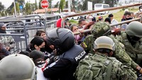 Kerabat narapidana mendorong pagar saat bentrok dengan polisi ketika mereka mencoba mencari tahu apakah orang yang mereka cintai termasuk di antara yang tewas menyusul kerusuhan di penjara Cotopaxi No 1, di Latacunga, Ekuador 4 Oktober 2022.