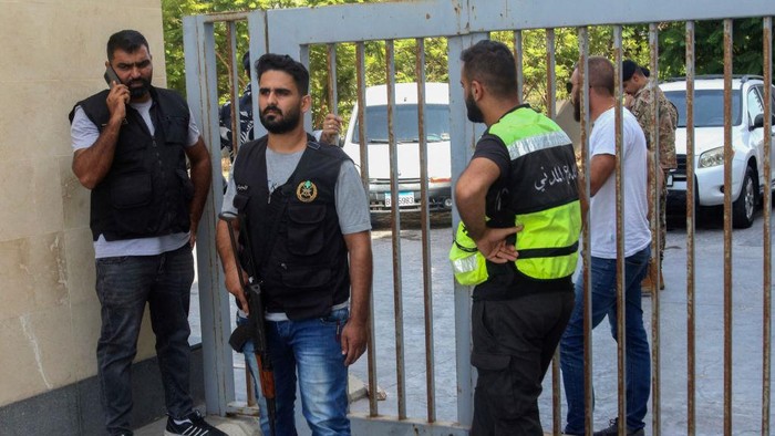 Members of Lebanon's security forces and emergency services deploy at a bank branch held-up by an angry depositor demanding access to his savings, in the southern city of Tyre, on Octobre 4, 2022. - A retired Lebanese officer stormed a bank demanding a money transfer for his son studying in Ukraine, an advocacy group said, one of at least three bank hold-ups across Lebanon. (Photo by Mahmoud ZAYYAT / AFP) (Photo by MAHMOUD ZAYYAT/AFP via Getty Images)