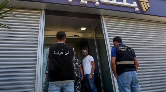 Members of Lebanon's security forces and emergency services deploy at a bank branch held-up by an angry depositor demanding access to his savings, in the southern city of Tyre, on Octobre 4, 2022. - A retired Lebanese officer stormed a bank demanding a money transfer for his son studying in Ukraine, an advocacy group said, one of at least three bank hold-ups across Lebanon. (Photo by Mahmoud ZAYYAT / AFP) (Photo by MAHMOUD ZAYYAT/AFP via Getty Images)