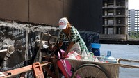 Xu sedang mengisi botol minuman dengan air bersih, yang diangkutnya dengan gerobak. Diketahui kompleks perumahan yang dikembangkan oleh Jiadengbao Real Estate di Guilin ini tidak teraliri air dan gas. Hasil tangkapan layar ini diambil dari video cuplikan 17 September 2022. REUTERS TV