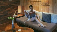 Bersantai di resort mewah saat di Bali. Anya sibuk membaca koran dan majalah dengan segelas minuman yang enak. Foto: Instagram @anyageraldine