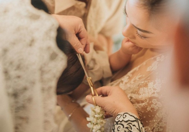 Begini momen saat rambut baby Izz digunting oleh sang nenek. Baby Izz terlihat nyaman berada di pelukan Nikita Willy. Foto: Instagram/@nikitawillyofficial94