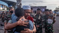 Anggota TNI AD dari Yon Zipur 5 memeluk seorang suporter Arema FC (Aremania) usai doa bersama di depan Tugu Singa, Stadion Kanjuruhan, Malang, Jawa Timur, Selasa (4/10/2022). Doa bersama ini dilakukan sebagai bentuk duka dari para anggota TNI kepada para korban. (Juni Kriswanto/AFP/Getty Images)