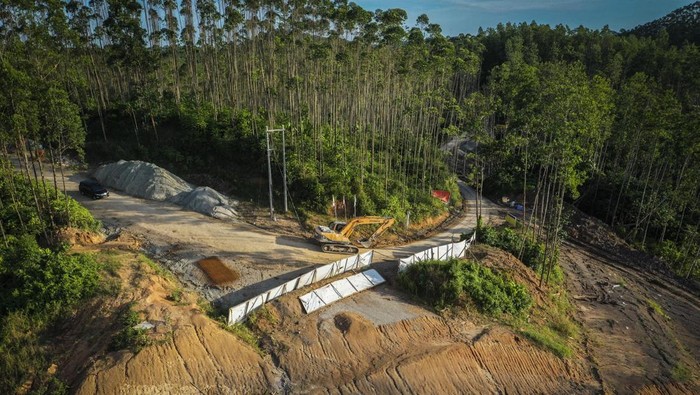 Pekerja dengan bantuan alat berat menyelesaikan pembangunan jalan lingkar Sepaku segmen 2 di Lokasi Ibu Kota Negara (IKN) Nusantara Kabupaten Penajam Paser Utara, Kalimantan Timur, Selasa (4/10/2022). Pemerintah pusat melalui Badan Otorita IKN terus meningkatkan intensitas pembangunan di wilayah IKN antara lain dengan pematangan lahan, pembangunan jalan akses logistik, intake air minum hingga persemaian pohon. ANTARA FOTO/Rivan Awal Lingga/tom.