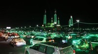 Mobil-mobil disinari dengan lampu dekorasi berwarna hijau melintas di Sanaa, Yaman, Selasa (4/10/2022). Pada malam hari warga Yaman akan parade dengan mobil yang telah dihiasi lampu hijau. Mereka mengelilingi kota seraya melantunkan selawat nabi.  