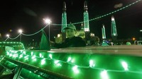 Seorang anak berdiri dari dalam mobil yang disinari dengan lampu dekorasi berwarna hijau di Sanaa, Yaman, Selasa (4/10/2022). Momen kelahiran Rasulullah SAW atau Maulid Nabi diperingati setiap 12 Rabiul Awal atau akan jatuh pada 7-8 Oktober 2022.  
