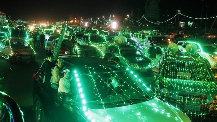 Sambut Maulid Nabi, Mobil-mobil di Yaman Menghijau Mobil-mobil disinari dengan lampu dekorasi berwarna hijau di Sanaa, Yaman, Selasa (4/10/2022) waktu setempat.