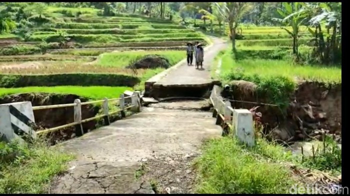 Sebuah jembatan penghubung antardes di Kabupaten Tasikmalaya, ambles pada Senin (3/10/2022).