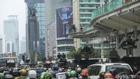 Parade alutsista TNI melintasi Bundaran HI. Warga di sekitar nampak antusias menyaksikan parade tersebut.