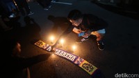 Berbagai wadah suporter saat menyalakan lilin bersama sembari berdoa di Stadion Mandala Krida. Foto: Pradito Rida Pertana/detikJateng