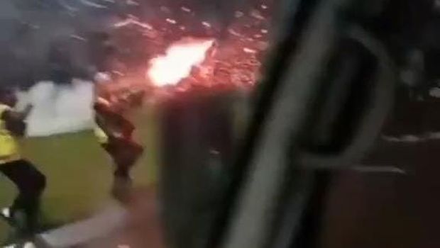 Tampak foto topi polisi yang berada di dashboard kendaraan perekam yang bahagia dengan aksi brutal Brimob ke suporter.