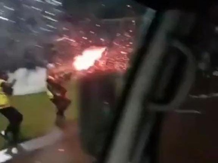 Tampak foto topi polisi yang berada di dashboard kendaraan perekam yang bahagia dengan aksi brutal Brimob ke suporter.