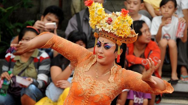 A Balinese woman (C) performs a traditional dance of Joget Bumbung during the 35th Bali Art Festival in Denpasar on Indonesia's resort island of Bali on July 4, 2013.  The Joged Bumbung Dance is one of the few exclusively secular dances of Bali, in which the brightly-dressed dancer invites men from the crowd to dance with her in a pretence of seduction.     AFP PHOTO / SONNY TUMBELAKA        (Photo credit should read SONNY TUMBELAKA/AFP via Getty Images)