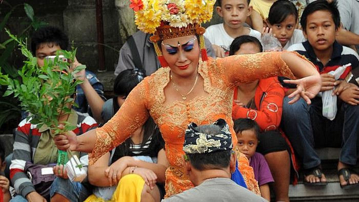 A Balinese woman (C) performs a traditional dance of Joget Bumbung during the 35th Bali Art Festival in Denpasar on Indonesias resort island of Bali on July 4, 2013.  The Joged Bumbung Dance is one of the few exclusively secular dances of Bali, in which the brightly-dressed dancer invites men from the crowd to dance with her in a pretence of seduction.     AFP PHOTO / SONNY TUMBELAKA        (Photo credit should read SONNY TUMBELAKA/AFP via Getty Images)